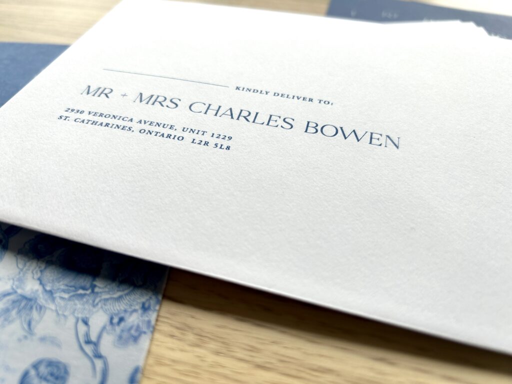 Wedding invitation addressing "Mr & mrs charles bowen" in blue ink on white envelope